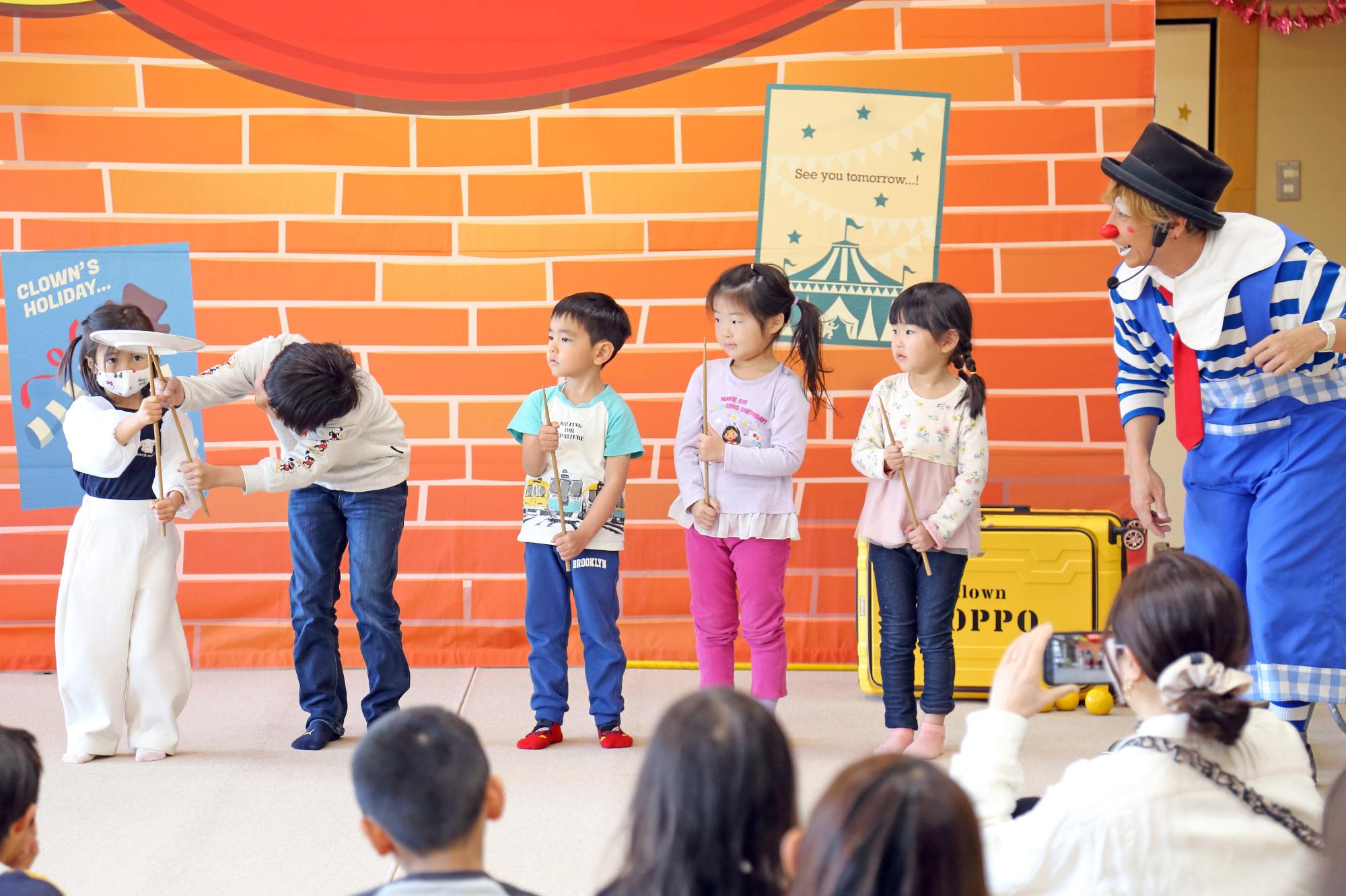 こどもたちがステージ上で皿回しに挑戦する様子