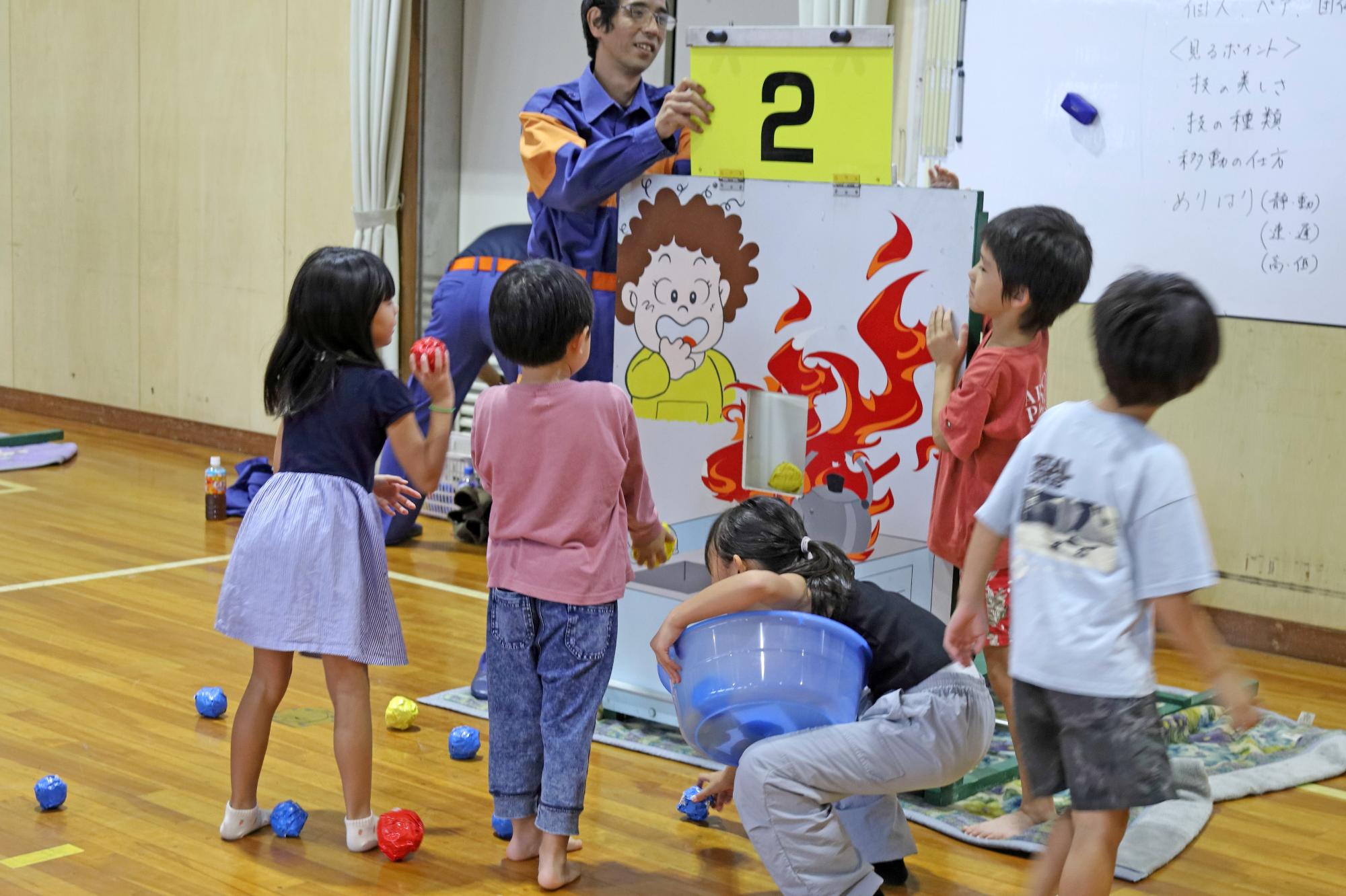 消防団の団員とこどもたちがゲームで遊んでいる様子の写真
