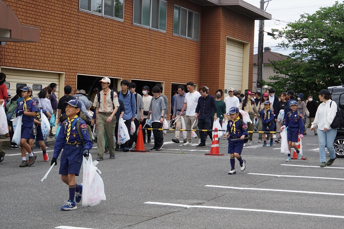 ごみ拾いを終えた参加者たちが市役所駐車場に集まる様子の写真