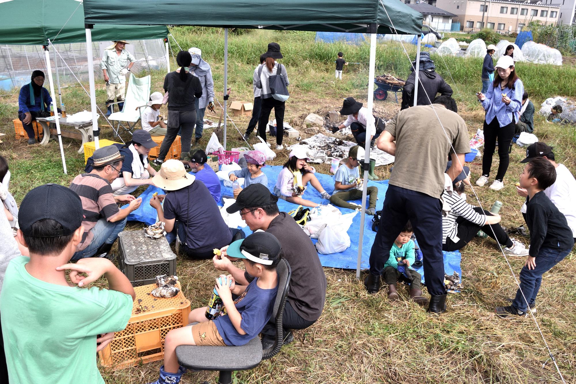 焼き芋を食べる参加者たちの写真