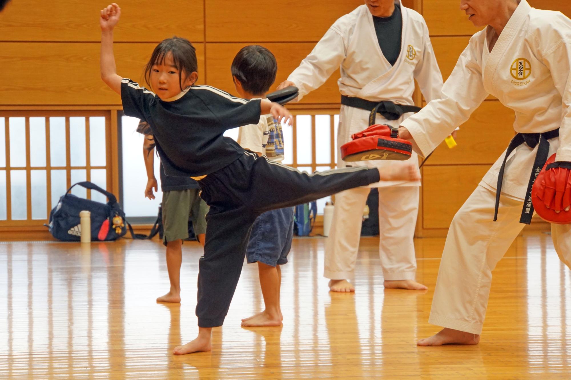 後ろ蹴りの練習をする参加者の女の子の写真