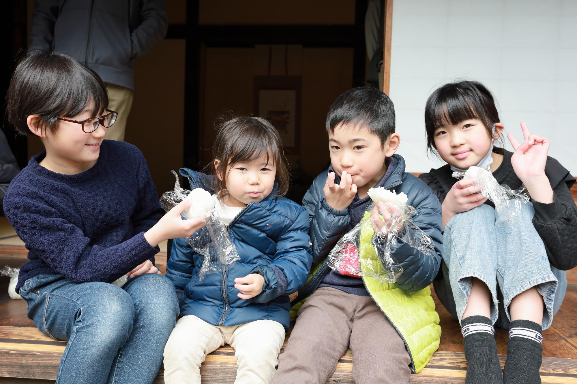 おにぎりを持って笑顔で映る子どもたちの写真