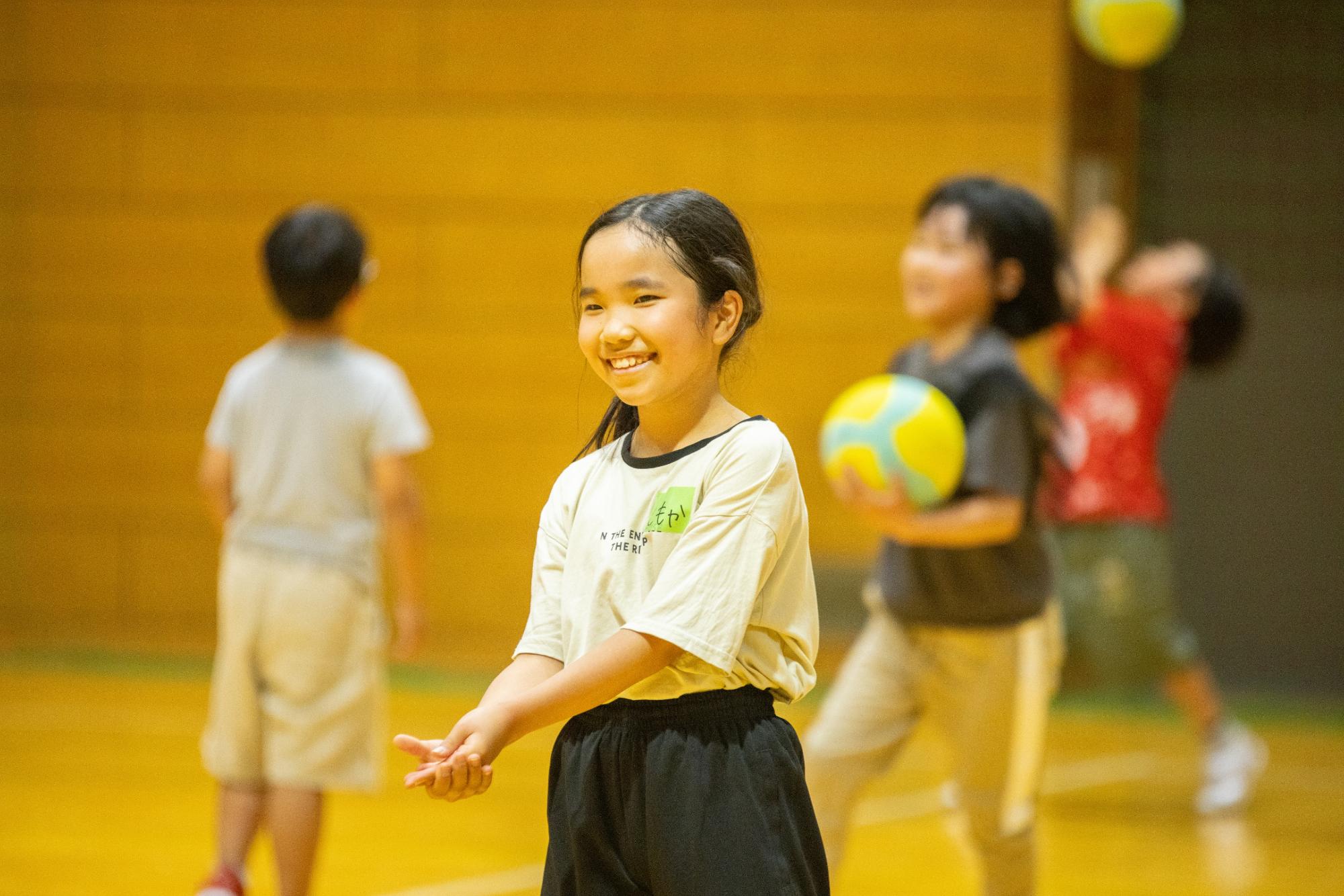 笑顔でバレーボールの練習をする女の子の写真
