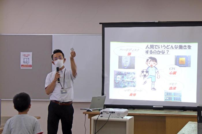 講師がパソコンのパーツを持つ写真その1