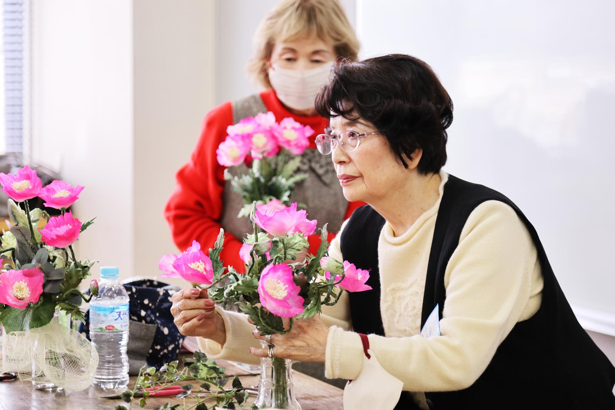 講師が布で使った花を手で整えている写真