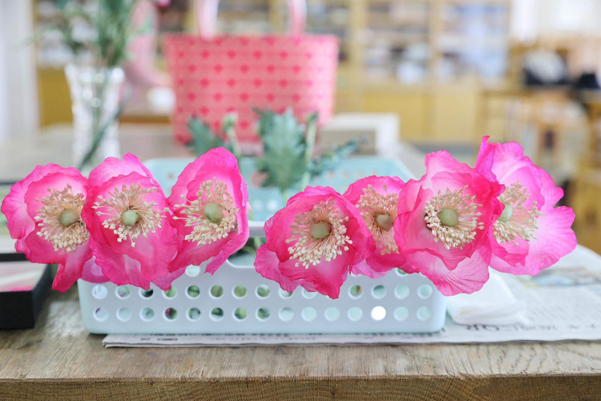 布で作ったポピーの花が机に並んでいる写真