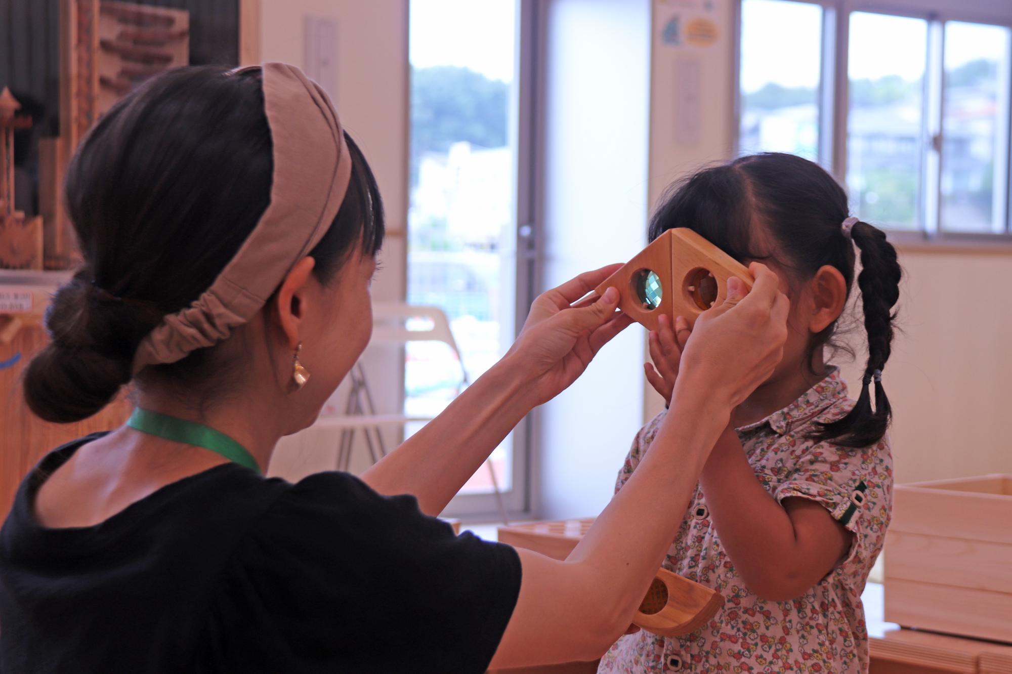 子どもとお母さんが木のおもちゃで一緒に遊んでいる写真