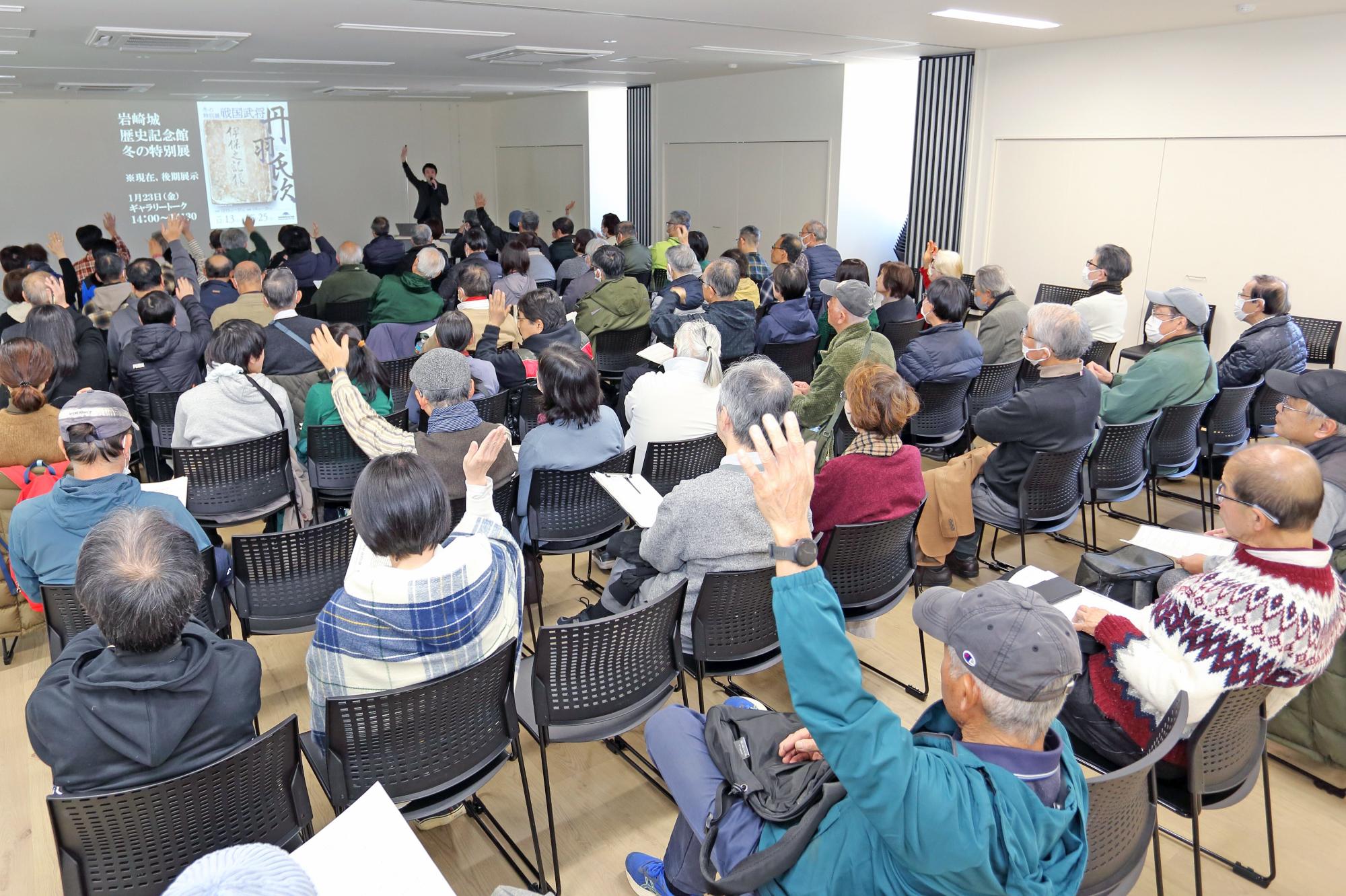 手を挙げる参加者たちの写真