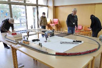 鉄道模型の展示を設営するスタッフの写真その1