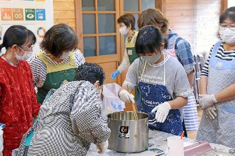 子どもの参加者が鍋の中で材料を混ぜ合わせる写真