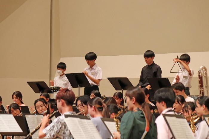 会場練習を行う愛知県立芸術大学ウインドオーケストラと子どもたちの写真