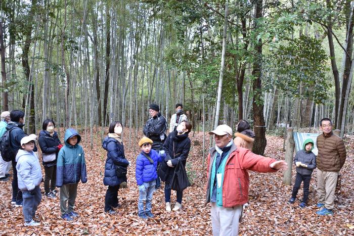 講師が参加者に里山を案内する写真