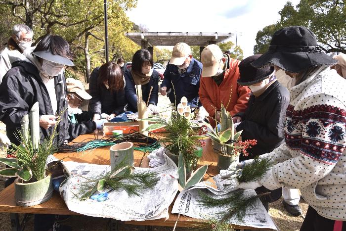 作業台の上でそれぞれの参加者が門松を作っている写真