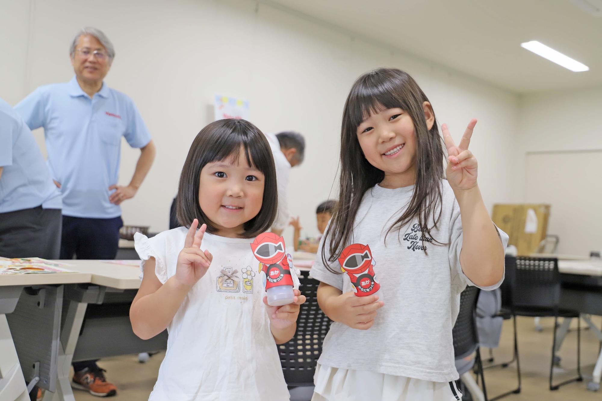 参加者のこどもたちが手に工作物を持ってピースしている写真