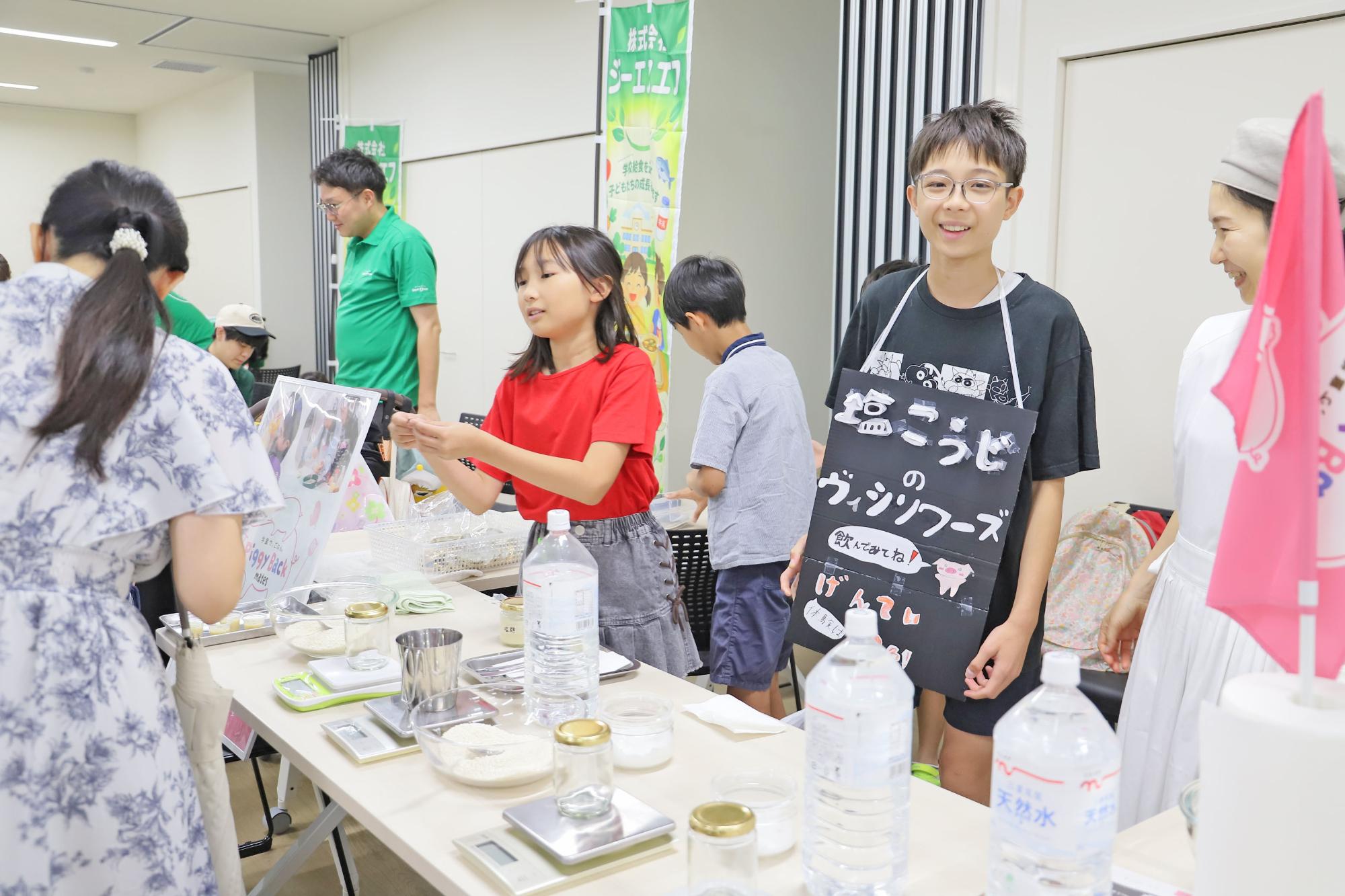 こどもたちが参加者に対して接客を行っている写真