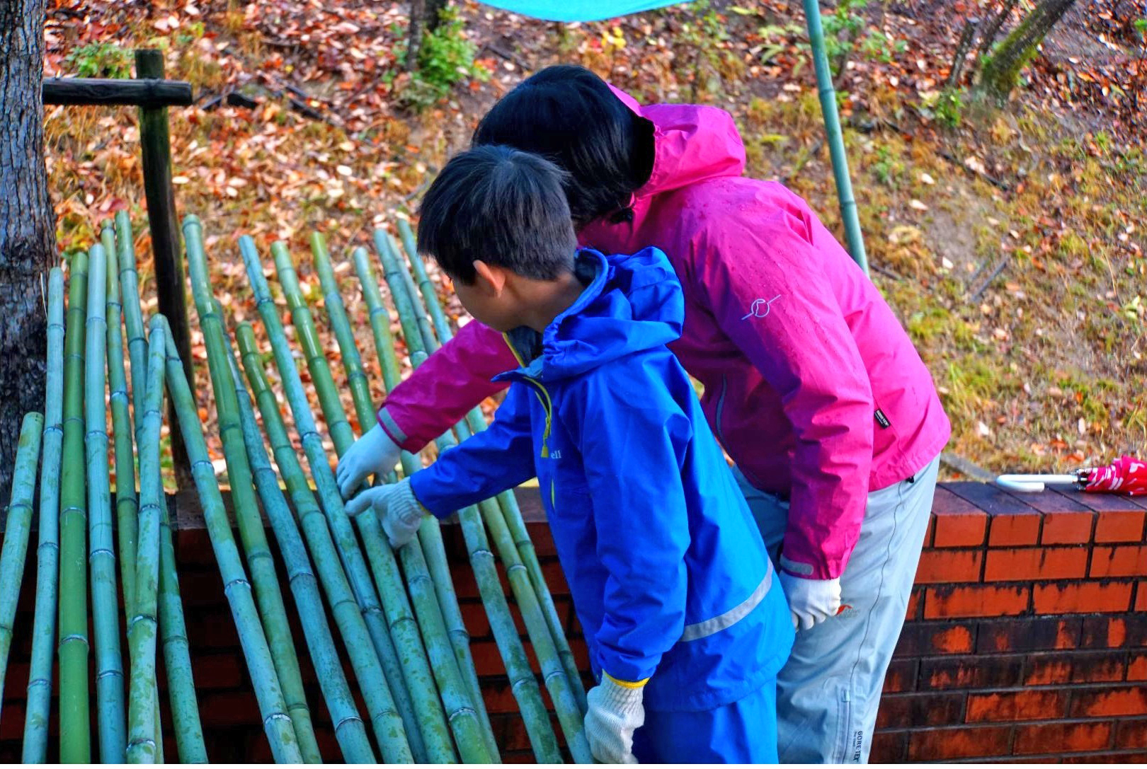 材料となる竹を手に取って選ぶ参加者の写真