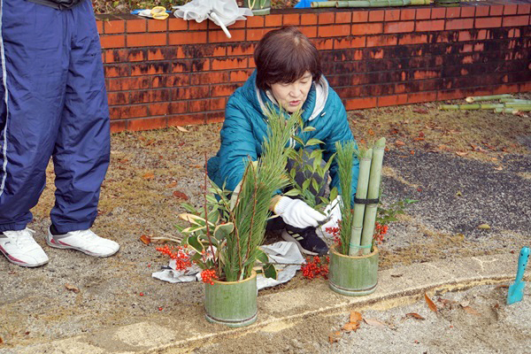 門松に飾りつけを行う参加者の写真
