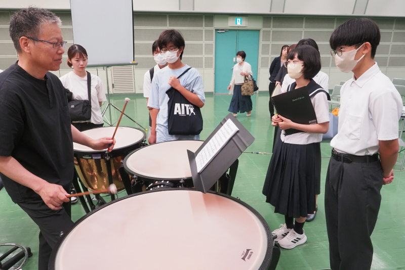 学生の参加者に演奏の指導を行う講師の写真
