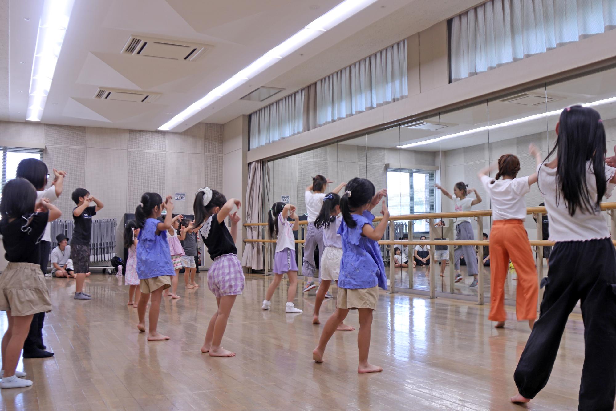 ダンスの振り付けを鏡の前で練習している子どもたちの写真