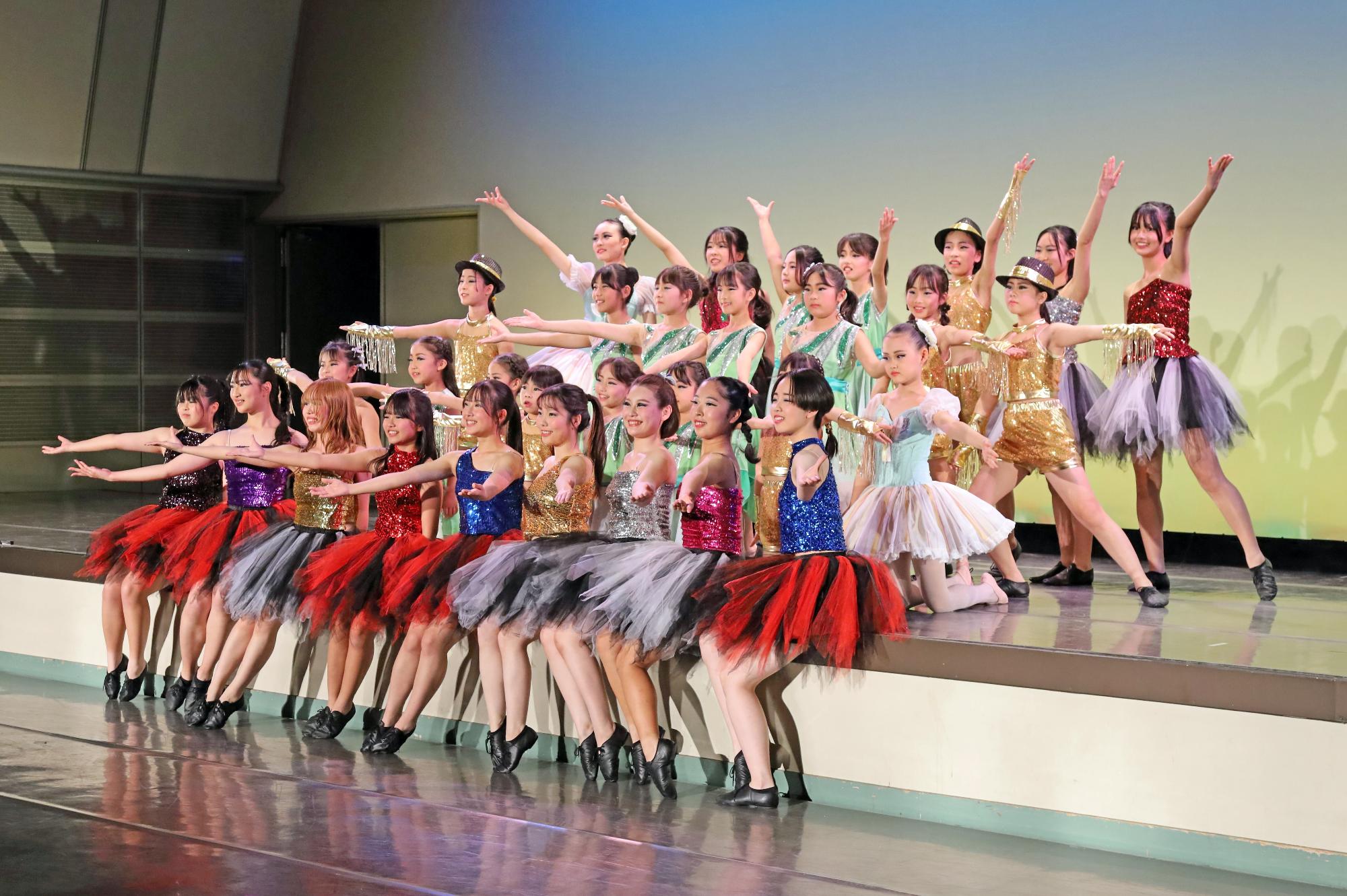 ステージ上に集まって決めポーズをとるこどもたちの写真