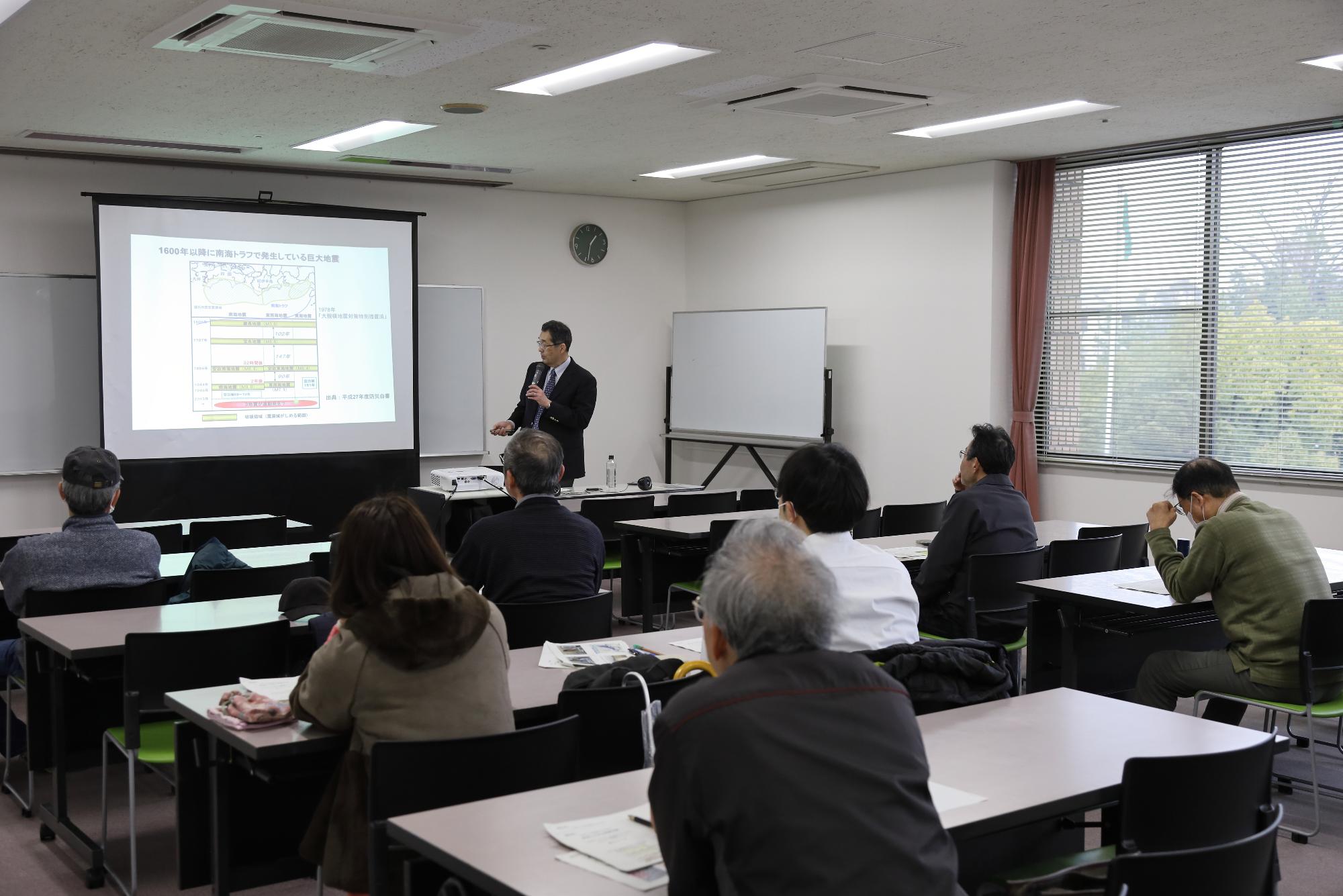 講師の先生が投影された資料を使って参加者に説明を行う写真