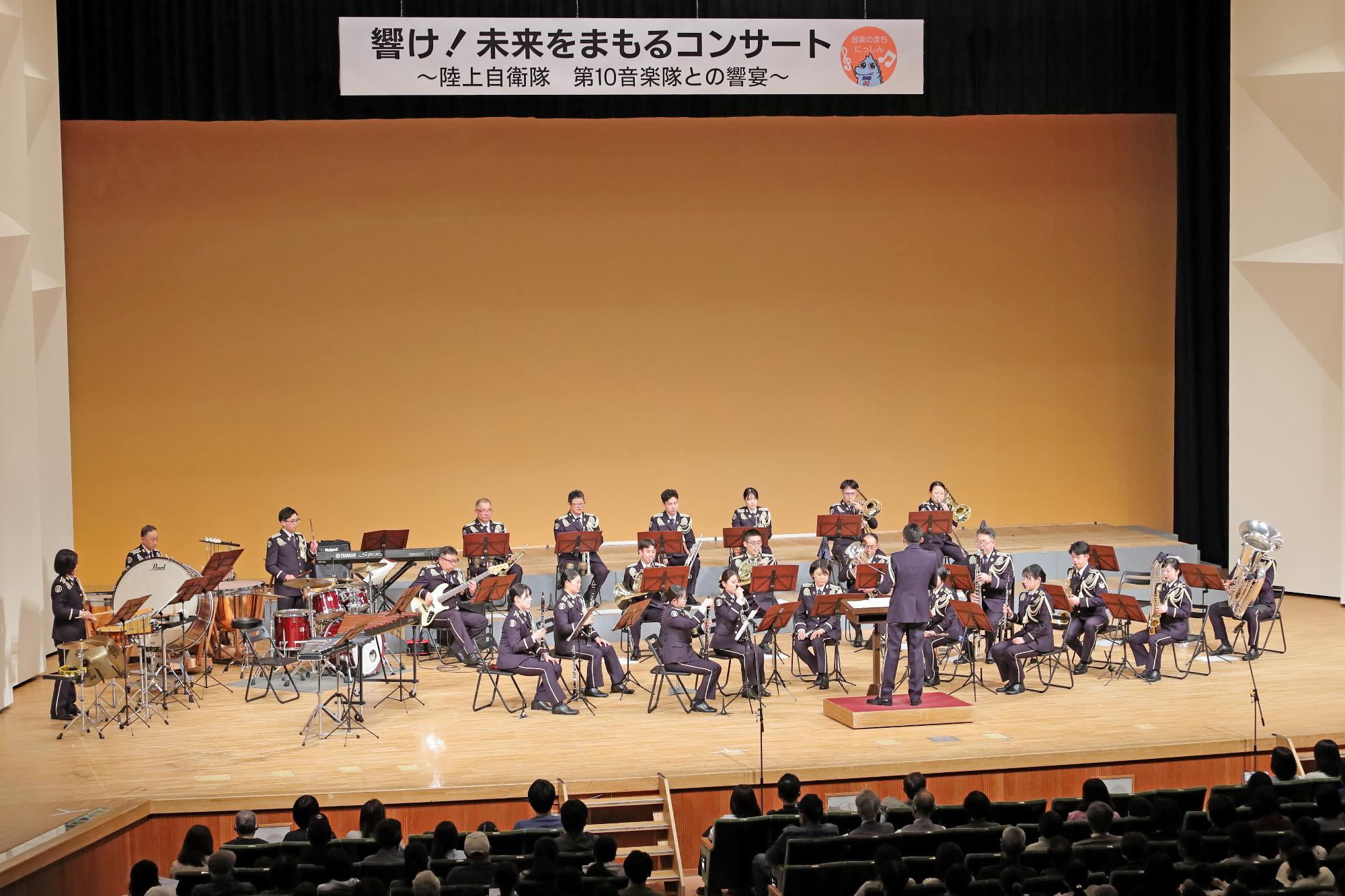 ステージ上で演奏を行う音楽隊の写真