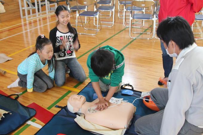 人形を使用し、AEDの使い方の訓練を受ける小下区政の写真