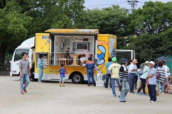 愛知県所有の地震体験車（なまず号）に並ぶ人たちの写真
