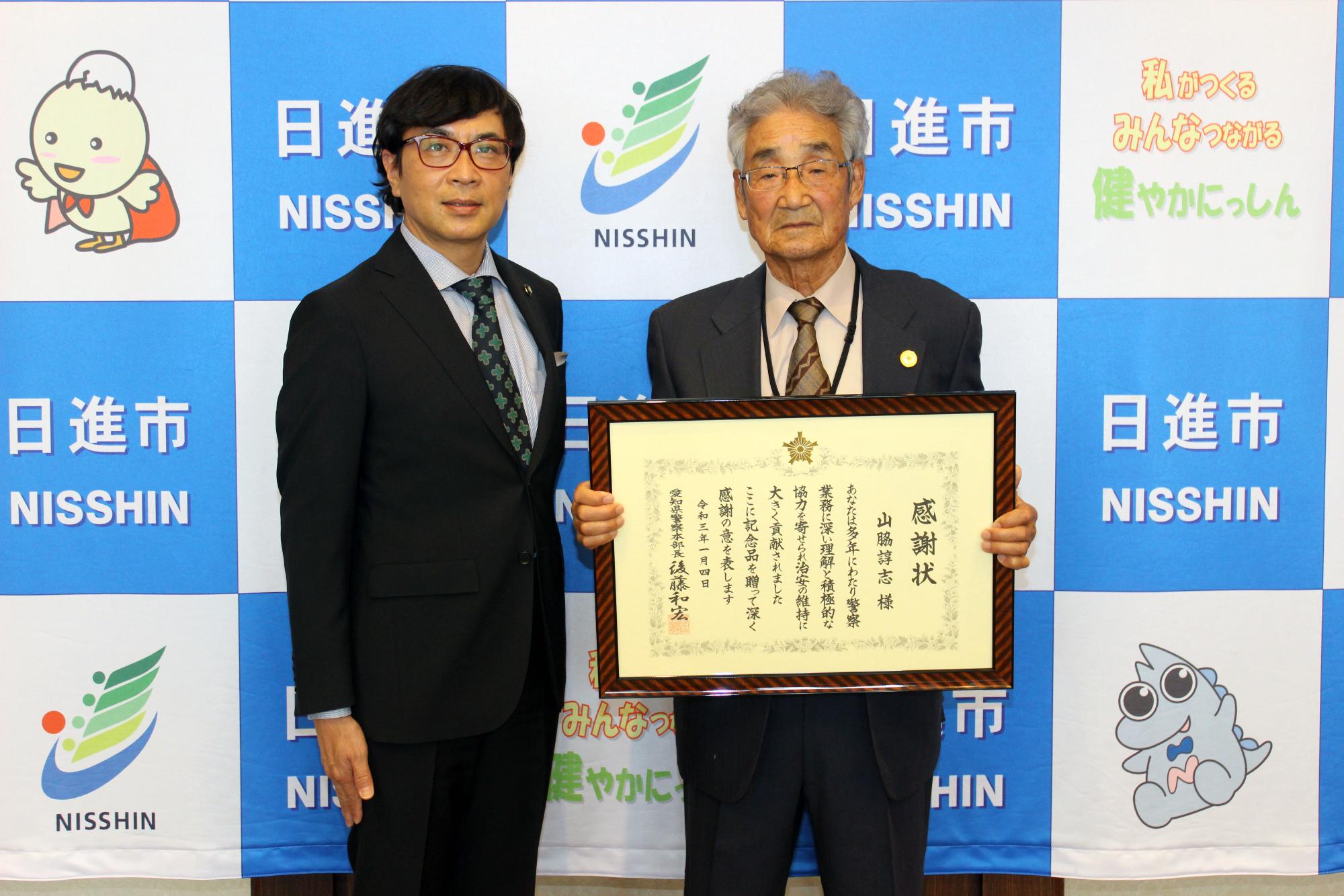 県警本部長表彰を受賞した山脇詢志さんと写真を撮る近藤市長