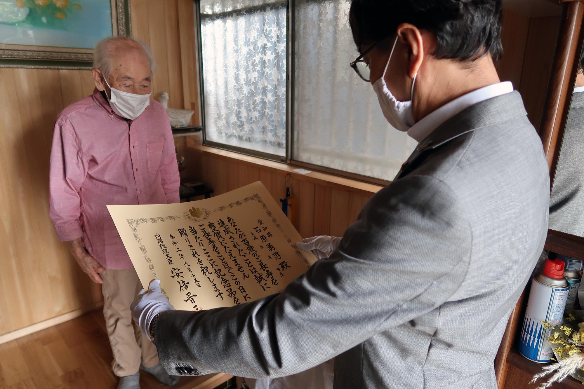 近藤市長からお祝い状を受け取る石原勇男さん