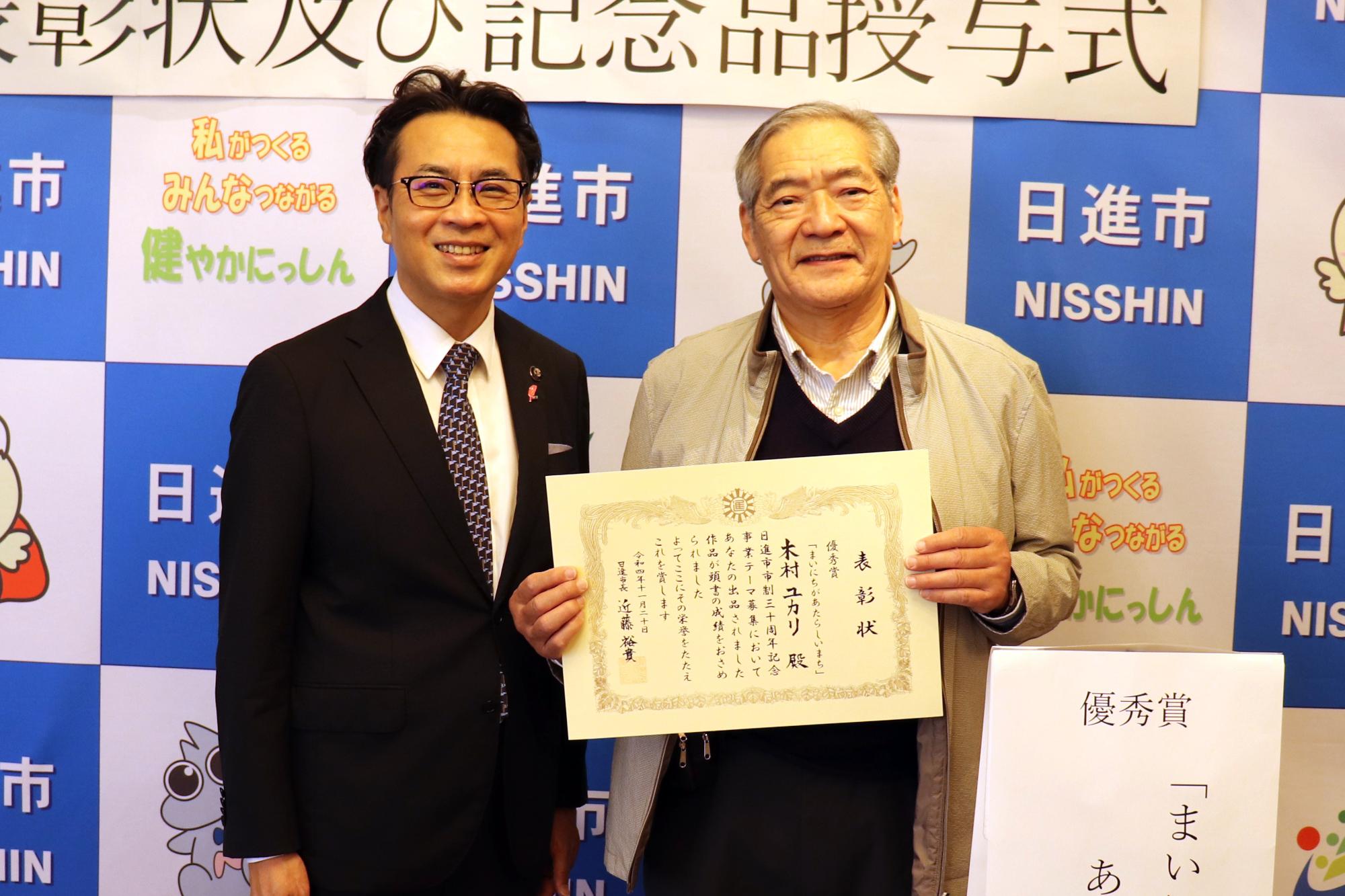 優秀賞を受賞した木村ユカリさんの代理人と記念撮影をする近藤市長