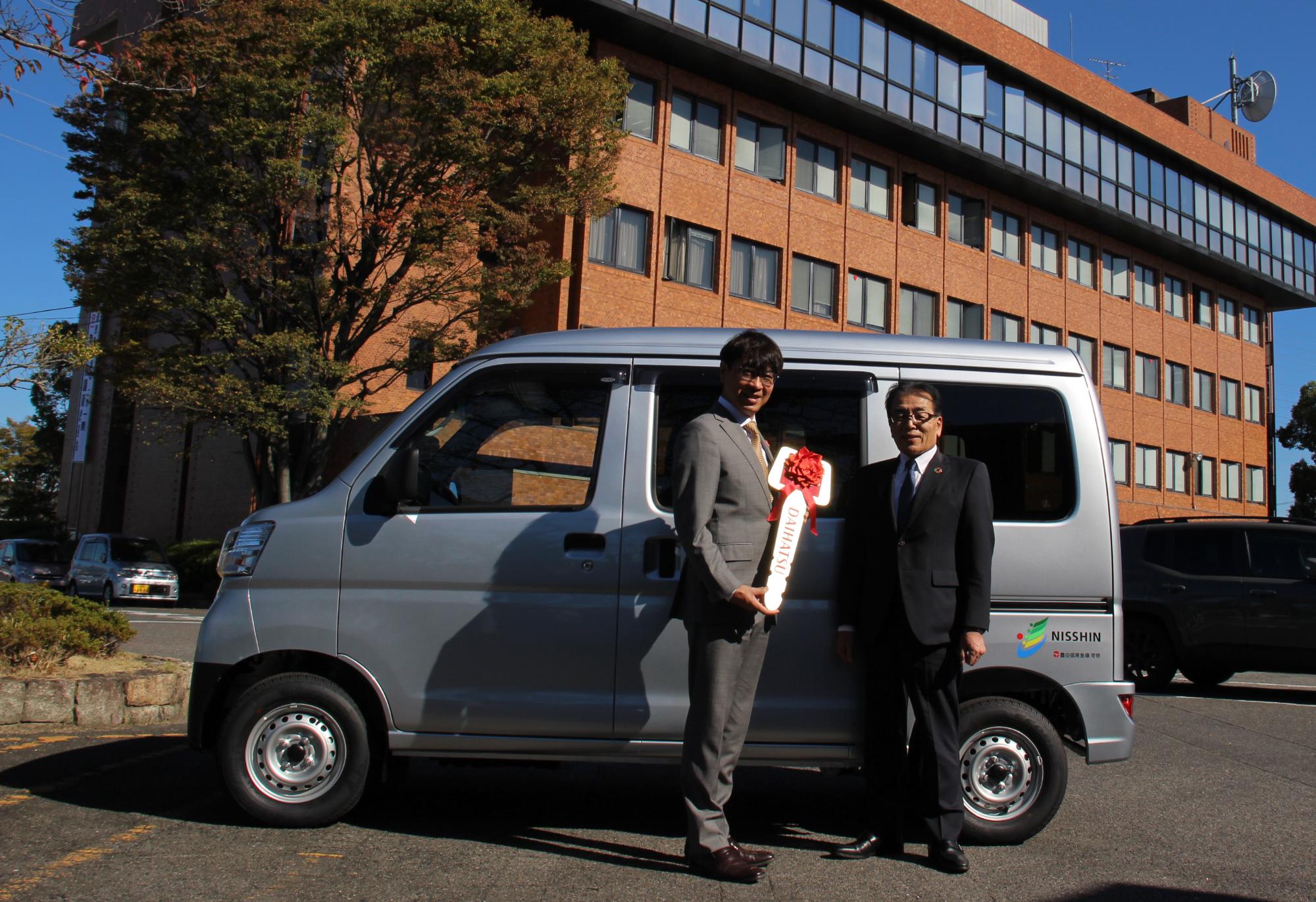 豊田信用金庫藤嶋理事長と贈呈車両の前で記念撮影をする近藤市長