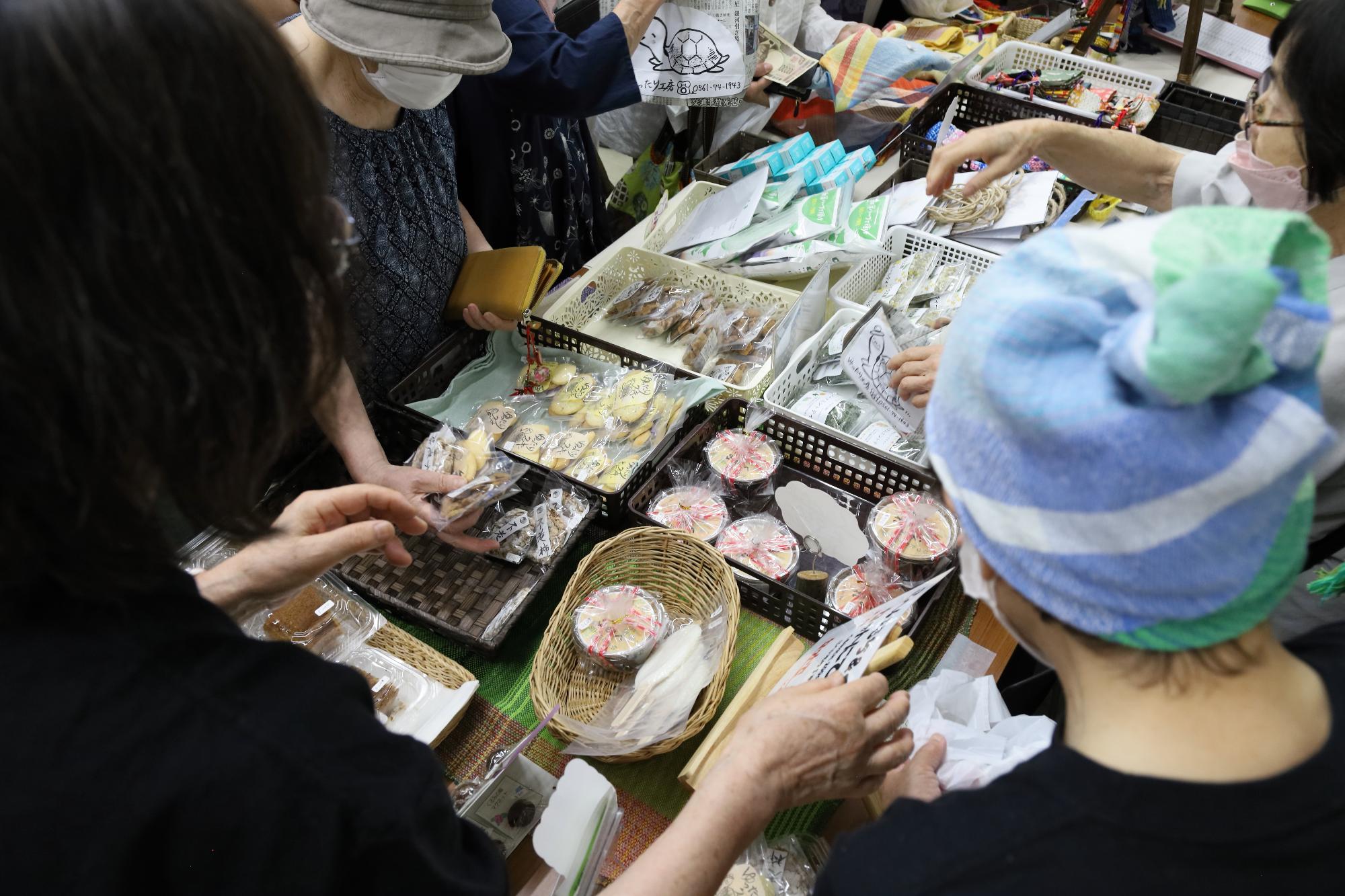 お菓子や雑貨の展示ブースで商品を買う参加者の写真