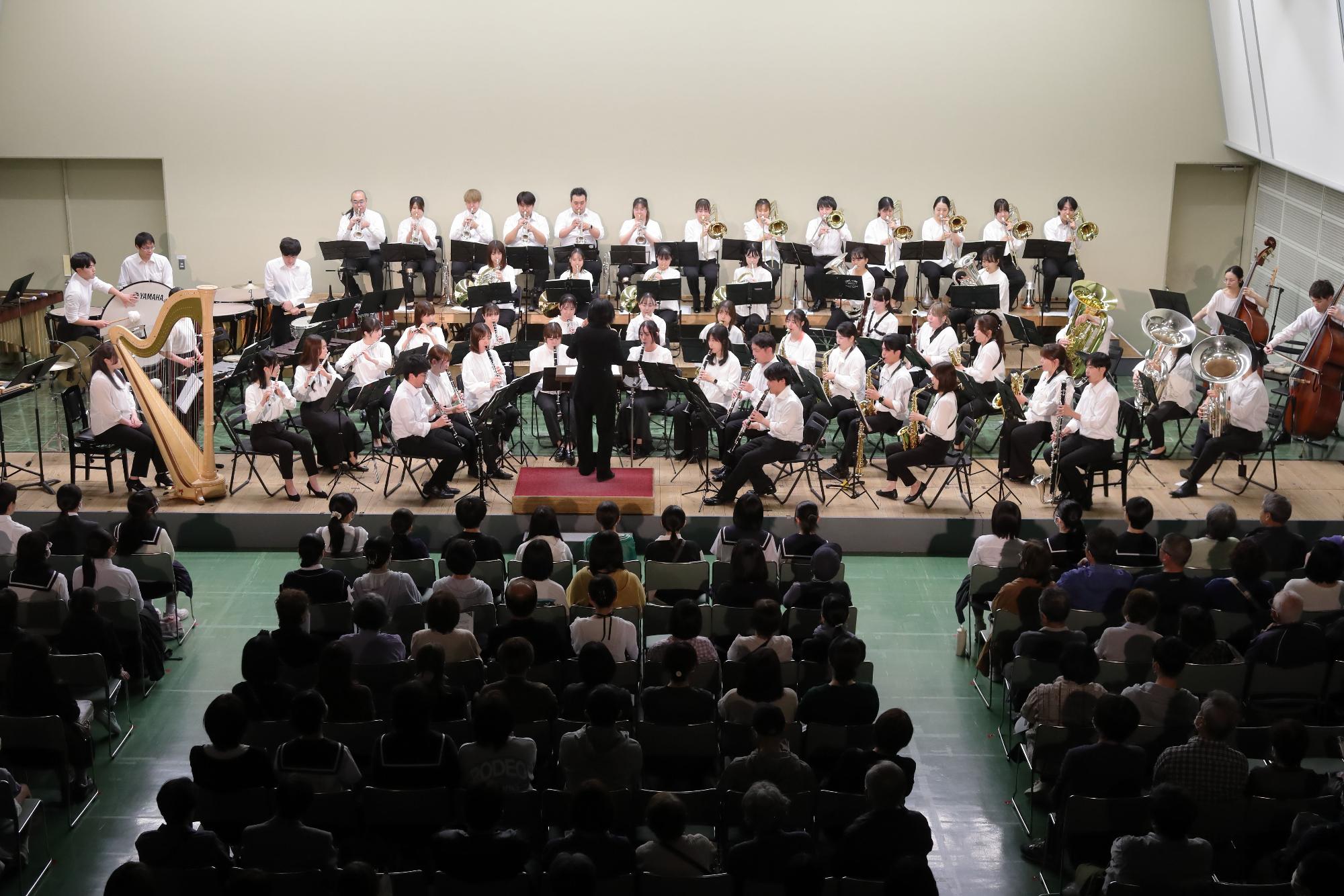 真剣な様子で演奏する団員と演奏に聞き入る観客の写真