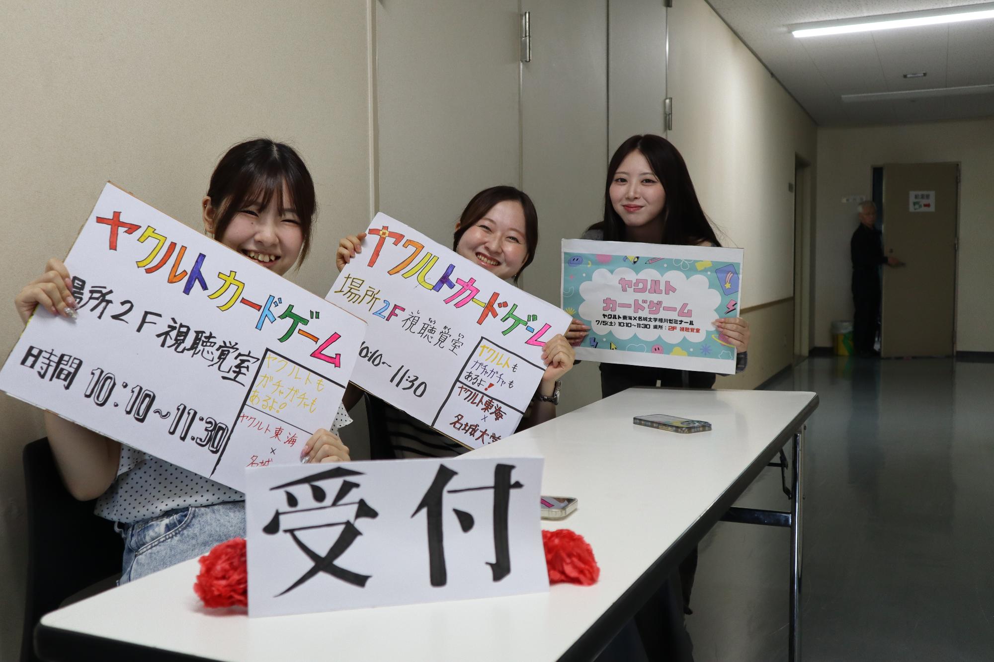 ヤクルトカードゲームのボードを持つ大学生の写真