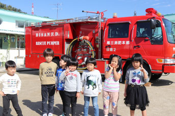 消防車の前で記念撮影をする園児たち