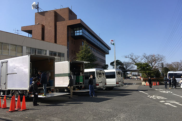 庁舎前で撮影機材を搬入するスタッフ