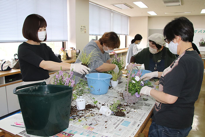 講師のアドバイスを参考に花材を植え付ける参加者