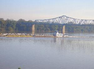 オハイオ川を渡る船の後ろに橋がかかっている風景の写真