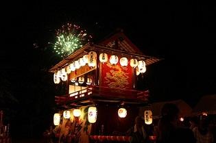 岩藤天王祭のおみこしのバックで花火が上がっている写真