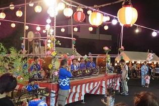 北新区盆踊り大会の舞台で子供たちが和太鼓を披露している写真
