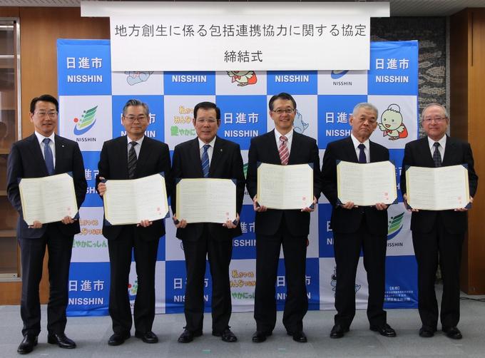 協定締結式で締結書を持っての集合写真