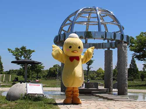 野方三ツ池公園の噴水「水の館」の前でポーズをとるへルピーの写真