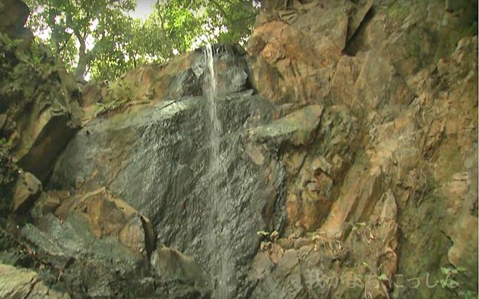 岩壁から流れ落ちている滝の写真