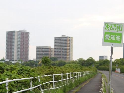 くるりんバスのバス停看板付近から望む米野木駅前の高層マンションの写真