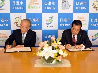 萩野幸三市長と広瀬茂協会けんぽ愛知支部長が締結式で署名を行っている写真