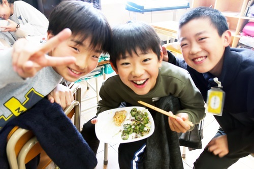給食を笑顔で食べる男児3人