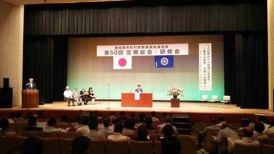 愛知県市町村教育委員会連合会第50回定期総会及び研修会にて壇上で演説をしている様子の写真