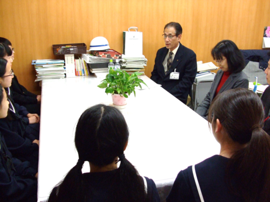 第29回中部日本個人・重奏コンテスト本大会に出場される日進西中学校吹奏楽部の皆さんが、顧問の先生とともに教育長へ報告をしに来た際に机を囲んで懇談している様子の写真