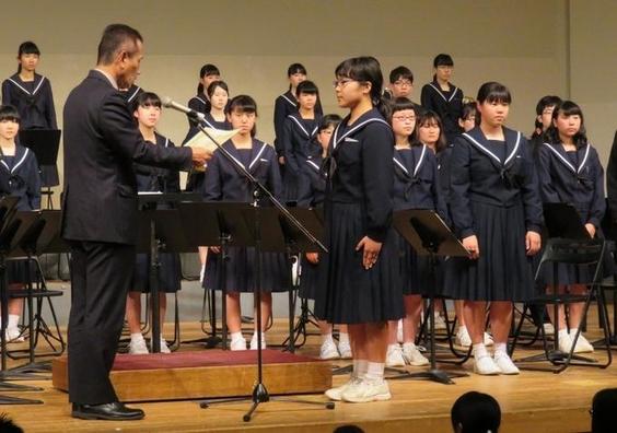 西中学校吹奏楽部定期演奏会にて教育長より賞状を授与されている女子生徒の写真